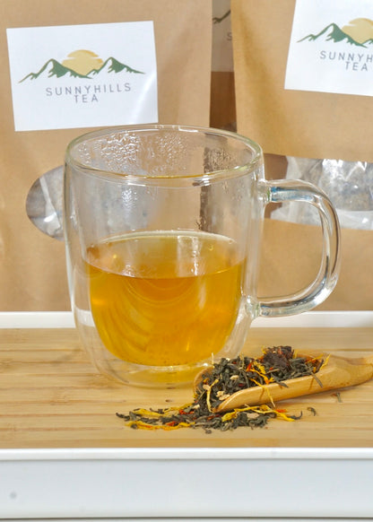 sunny-hills-tea-Organic-Ginger-Orange-Peach-Green-tea-brewed-with-packs-in-the-background